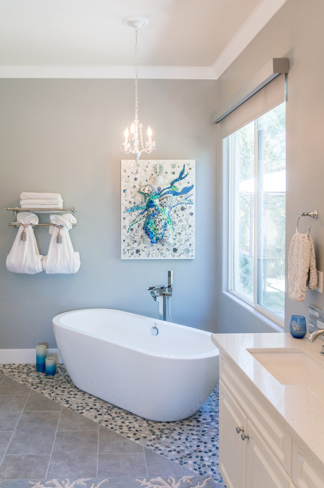 Photo of a large contemporary master bathroom in Other with raised-panel cabinets, white cabinets, a japanese tub, blue tile, glass tile, grey walls, ceramic floors, an undermount sink, quartzite benchtops and grey floor.