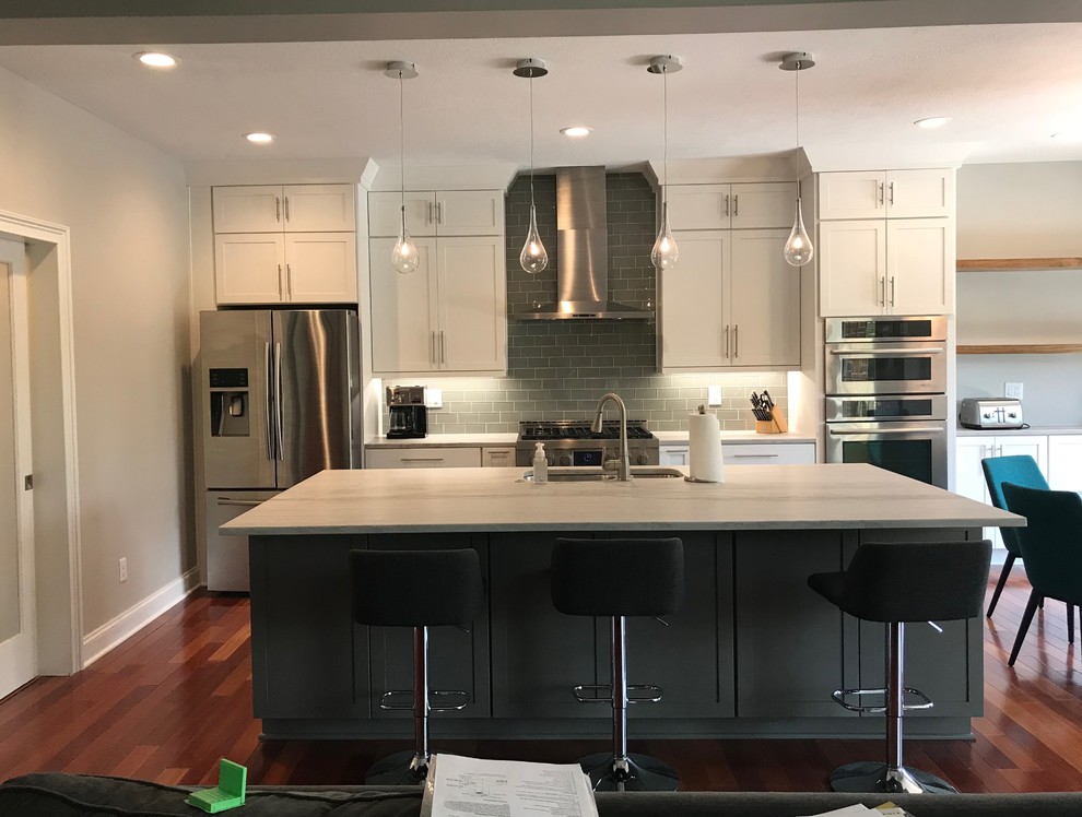 Inspiration for a mid-sized transitional single-wall medium tone wood floor and brown floor eat-in kitchen remodel with an undermount sink, shaker cabinets, white cabinets, quartzite countertops, gray backsplash, glass tile backsplash, stainless steel appliances, an island and multicolored countertops