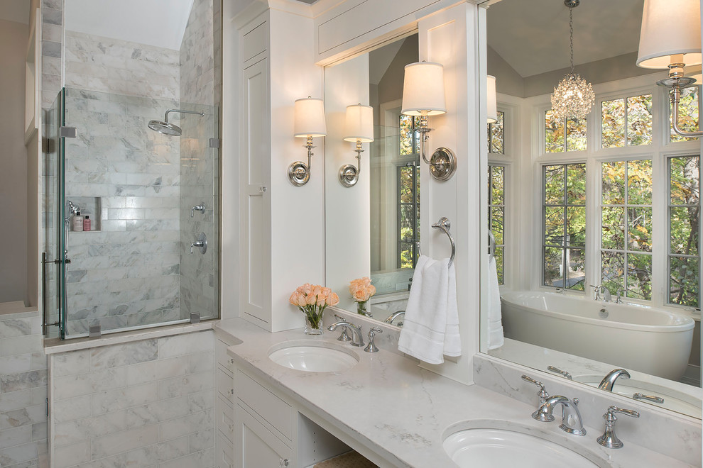 Photo of a large traditional master bathroom in Milwaukee with shaker cabinets, white cabinets, a freestanding tub, gray tile, marble, grey walls, marble floors, an undermount sink, quartzite benchtops, white floor, a hinged shower door and a corner shower.