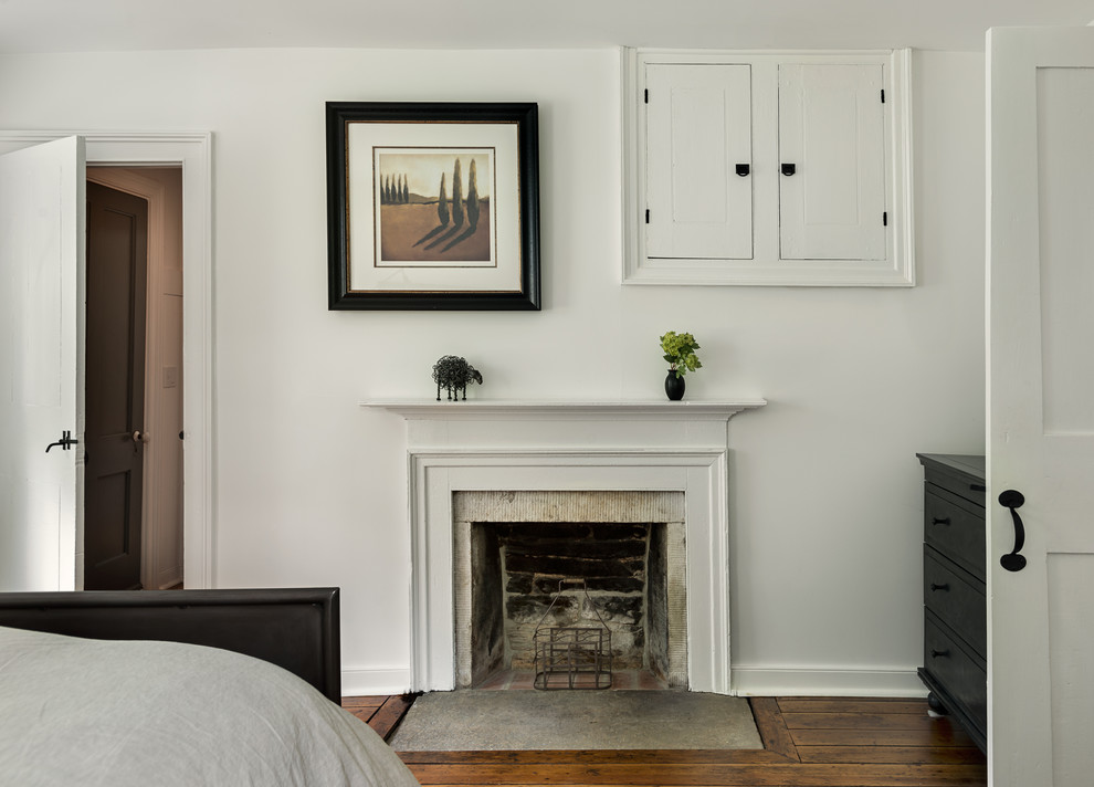 Inspiration for a country bedroom in New York with white walls and a standard fireplace.