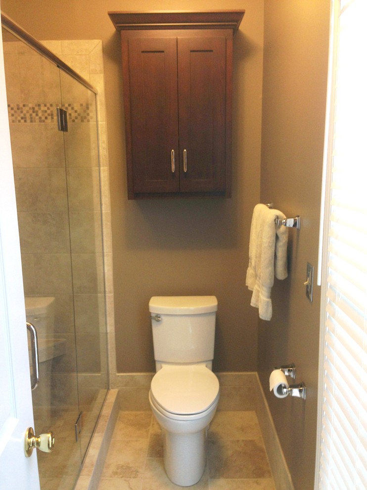 Inspiration for a small transitional brown tile and mosaic tile limestone floor alcove shower remodel with shaker cabinets, dark wood cabinets, a two-piece toilet and brown walls
