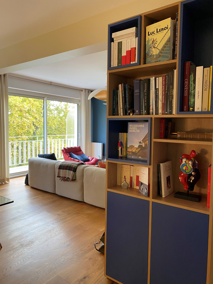 Immagine di un soggiorno minimal di medie dimensioni e aperto con pareti blu, parquet scuro e TV autoportante