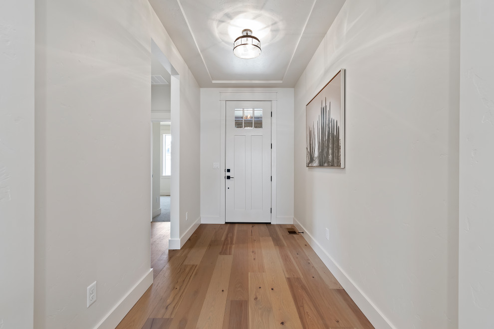 Mid-sized arts and crafts front door in Boise with white walls, medium hardwood floors, a single front door, a white front door, beige floor and recessed.