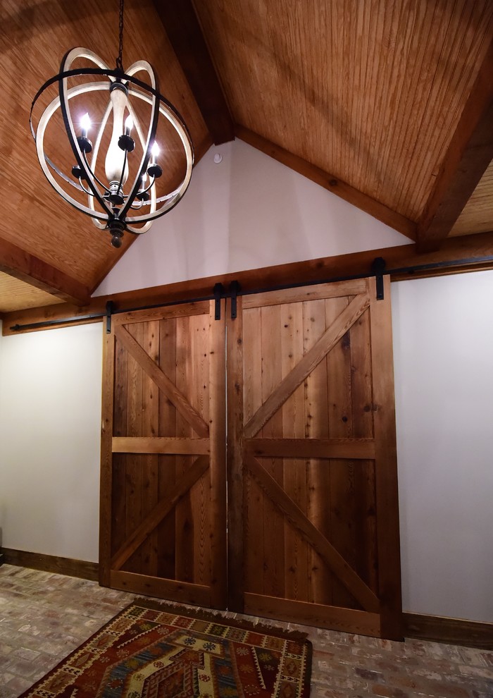 Example of a large mountain style brick floor foyer design with a medium wood front door