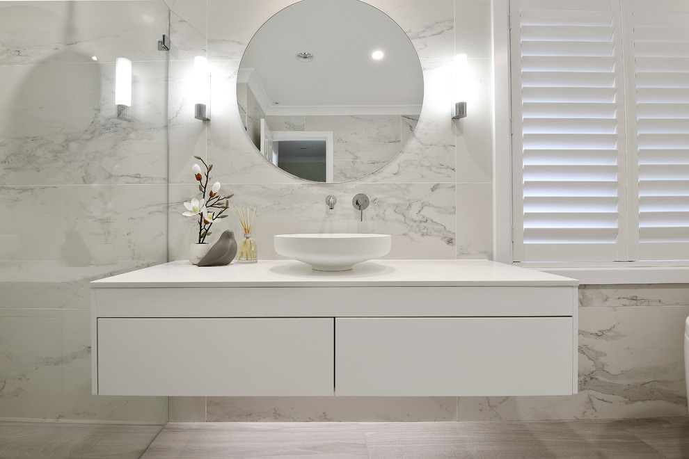 Photo of a mid-sized contemporary master bathroom in Sydney with glass-front cabinets, white cabinets, a freestanding tub, an open shower, multi-coloured tile, ceramic tile, multi-coloured walls, ceramic floors, a vessel sink, laminate benchtops, grey floor, an open shower and white benchtops.