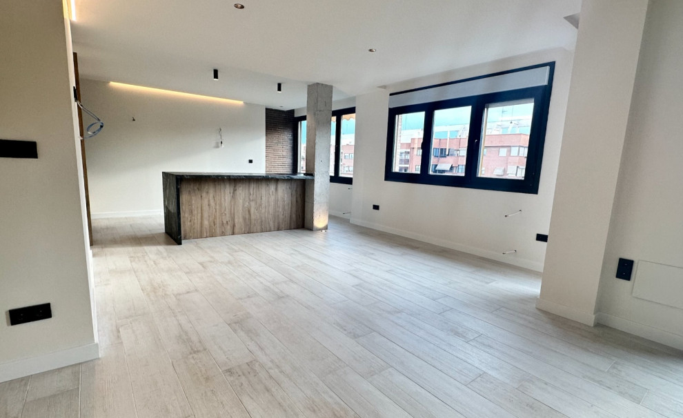 Imagen de sala de estar abierta industrial de tamaño medio con paredes beige, suelo de baldosas de porcelana y suelo beige