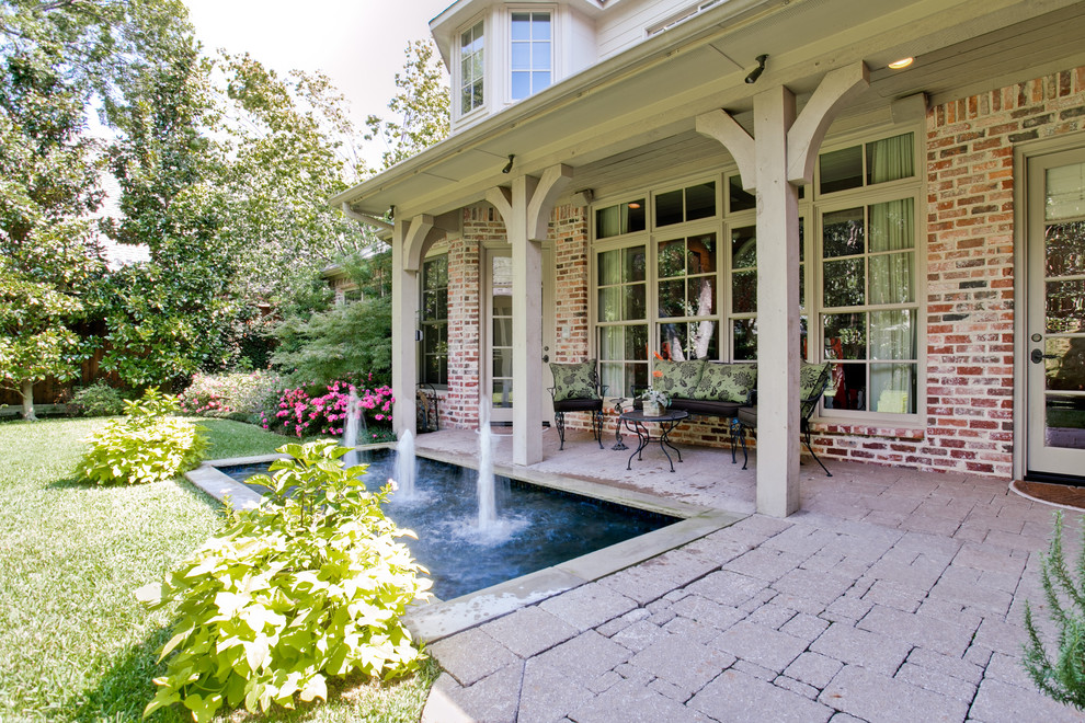 Inspiration for a traditional garden in Dallas with brick pavers and a water feature.