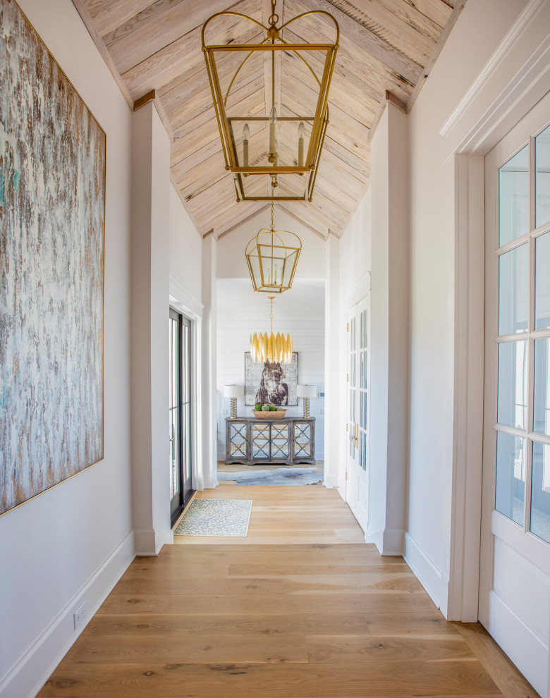 Immagine di un grande ingresso o corridoio country con pareti bianche, parquet chiaro, pavimento marrone, soffitto a volta e pareti in legno