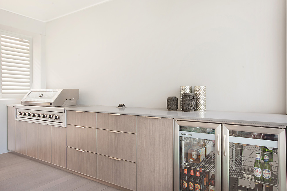 Mid-sized contemporary single-wall seated home bar in Newcastle - Maitland with no sink, flat-panel cabinets, medium wood cabinets, quartz benchtops, white splashback, medium hardwood floors, brown floor and grey benchtop.