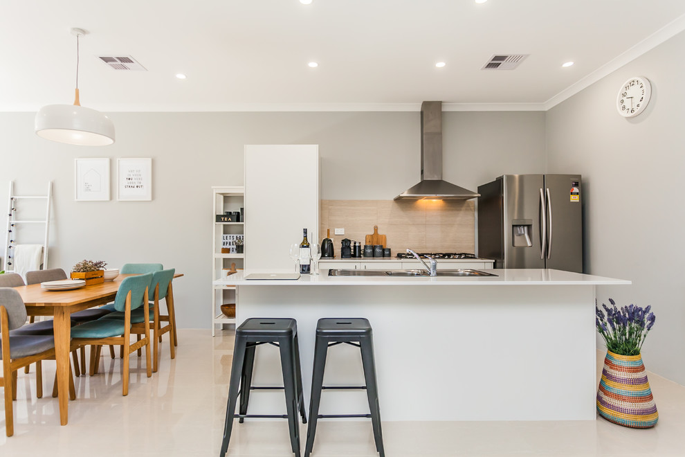 This is an example of a contemporary kitchen in Perth with a drop-in sink, white cabinets, beige splashback, stainless steel appliances and with island.
