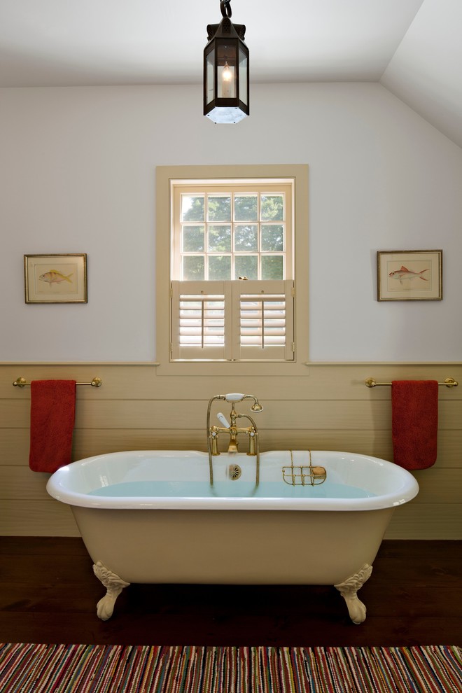 Country master bathroom in New York with multi-coloured walls, a claw-foot tub and dark hardwood floors.