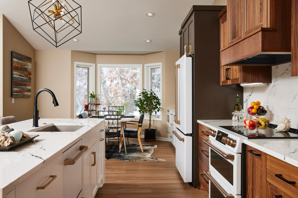 Inspiration for a large contemporary single-wall kitchen/diner in Minneapolis with a submerged sink, flat-panel cabinets, medium wood cabinets, engineered stone countertops, white splashback, engineered quartz splashback, white appliances, medium hardwood flooring, an island and brown floors.