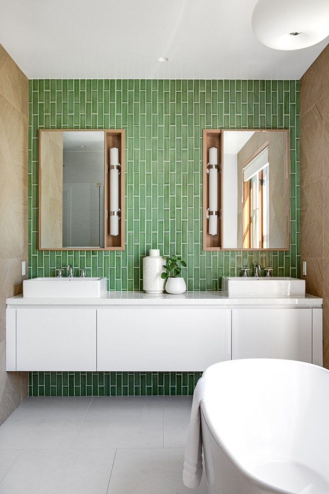 Design ideas for a mid-sized contemporary master bathroom in Orange County with flat-panel cabinets, white cabinets, a freestanding tub, green tile, ceramic tile, green walls, a vessel sink, quartzite benchtops, white benchtops, cement tiles and grey floor.