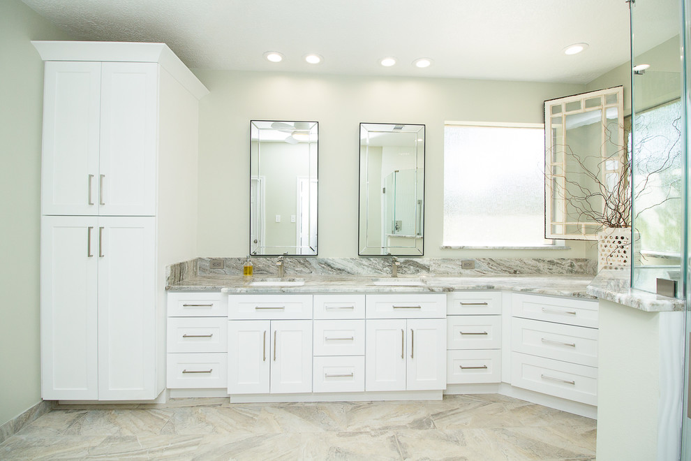 Photo of a large contemporary master bathroom in Houston with shaker cabinets, white cabinets, a corner shower, white tile, porcelain tile, grey walls, porcelain floors, an undermount sink, beige floor, a hinged shower door, quartzite benchtops and white benchtops.
