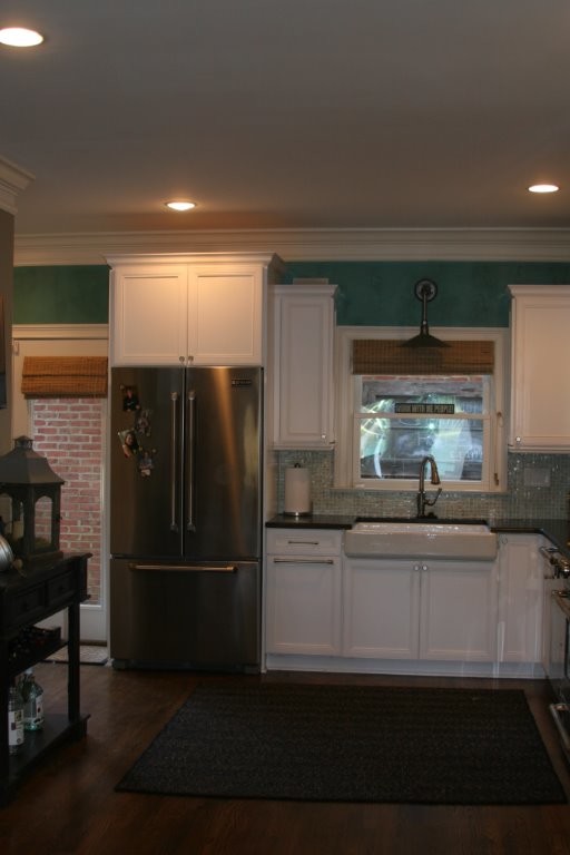 Photo of a transitional l-shaped eat-in kitchen in Atlanta with a farmhouse sink, recessed-panel cabinets, white cabinets, granite benchtops, grey splashback and coloured appliances.