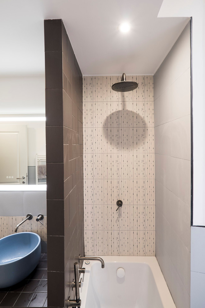 Immagine di una piccola stanza da bagno con doccia con vasca ad alcova, piastrelle in gres porcellanato, top piastrellato, top nero e un lavabo