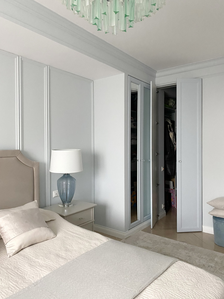 This is an example of a large gender neutral walk-in wardrobe in Moscow with flat-panel cabinets, grey cabinets, light hardwood flooring and beige floors.