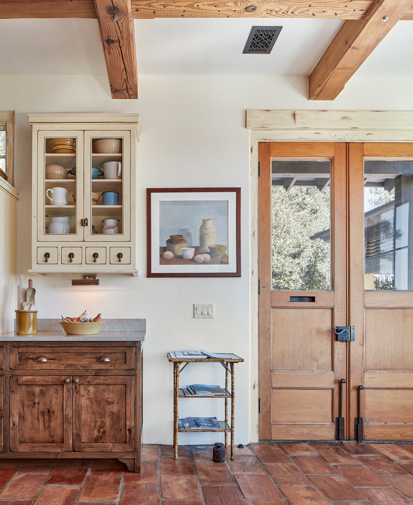 This is an example of a large mediterranean kitchen in Atlanta with distressed cabinets and terra-cotta floors.