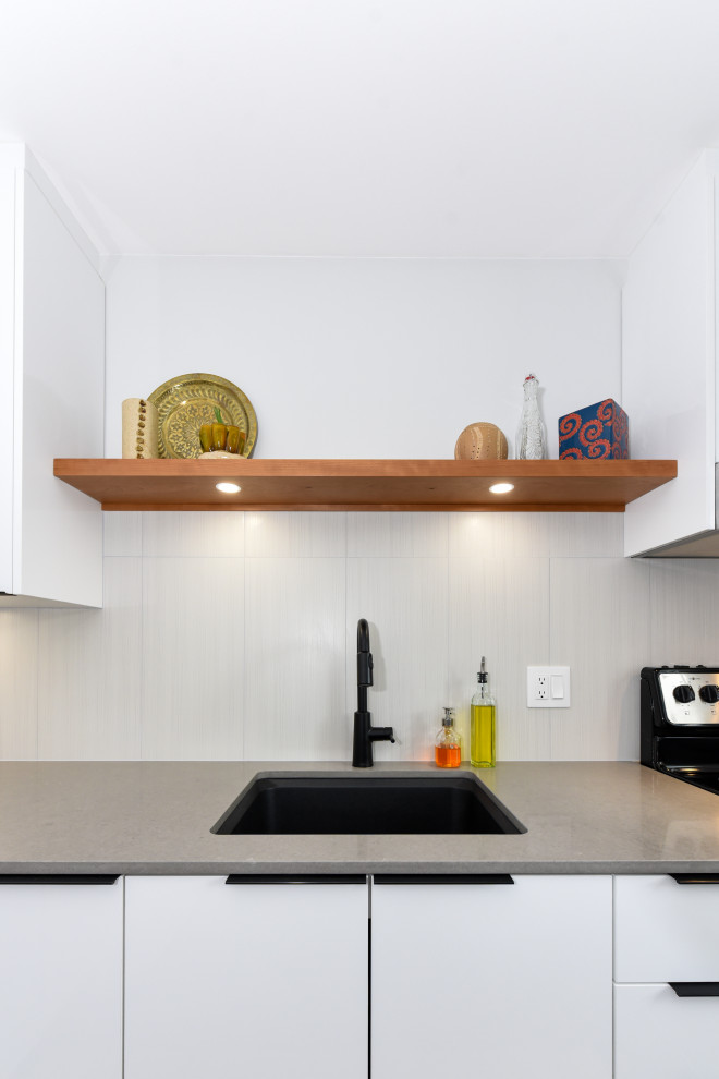 Photo of a small modern l-shaped separate kitchen in Ottawa with an undermount sink, flat-panel cabinets, white cabinets, quartz benchtops, beige splashback, white appliances and grey benchtop.