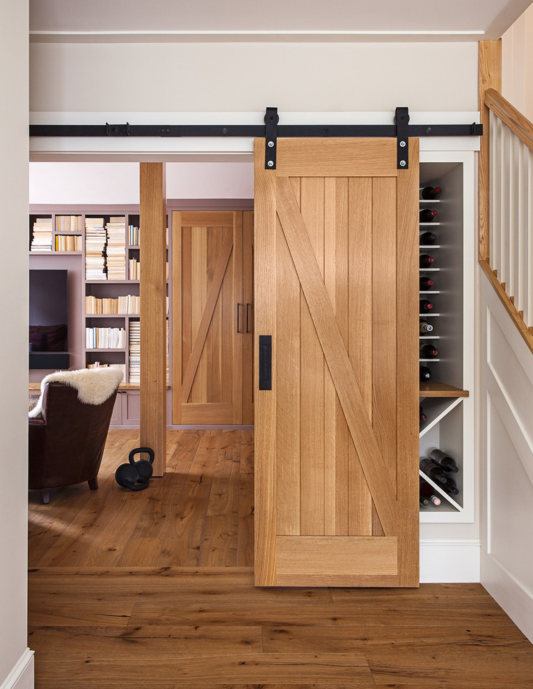 Photo of a mid-sized arts and crafts hallway in San Francisco with white walls, medium hardwood floors and brown floor.