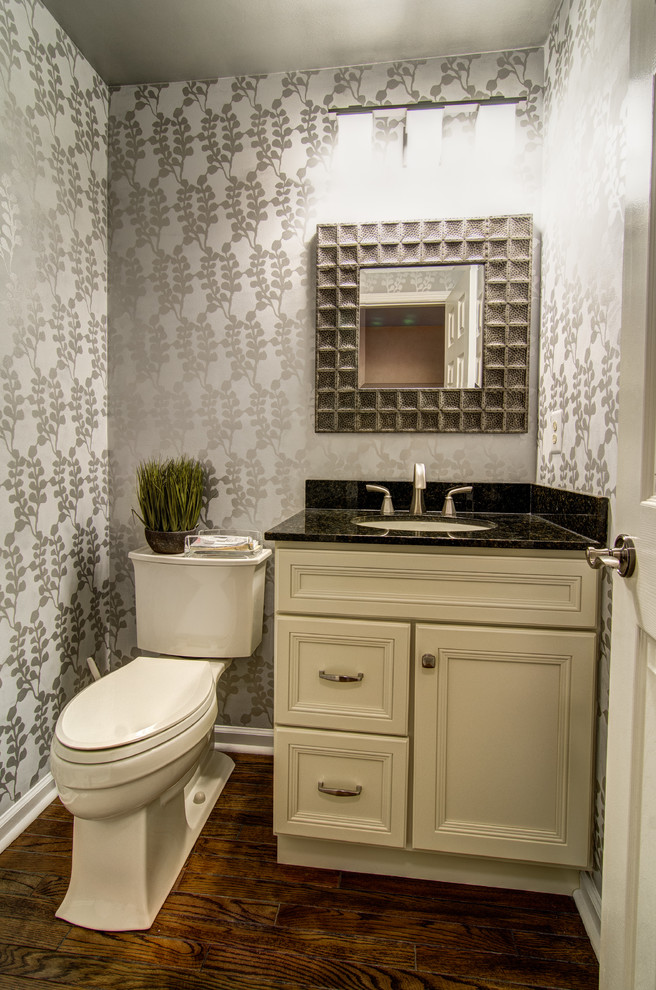 Small traditional powder room in Philadelphia with an undermount sink, flat-panel cabinets, granite benchtops, a two-piece toilet, grey walls, dark hardwood floors, beige cabinets and black benchtops.