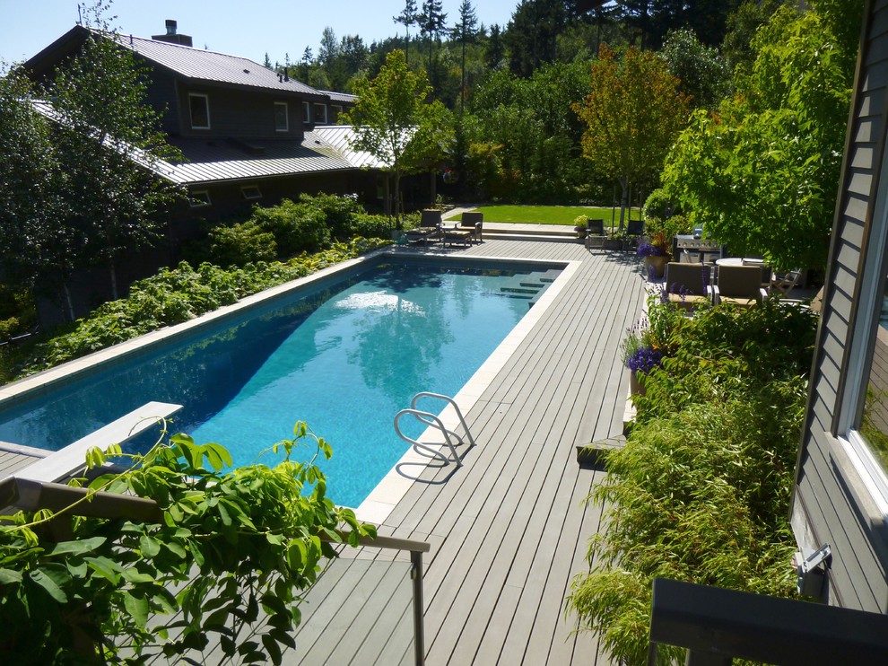Contemporary backyard rectangular pool in Seattle with decking.