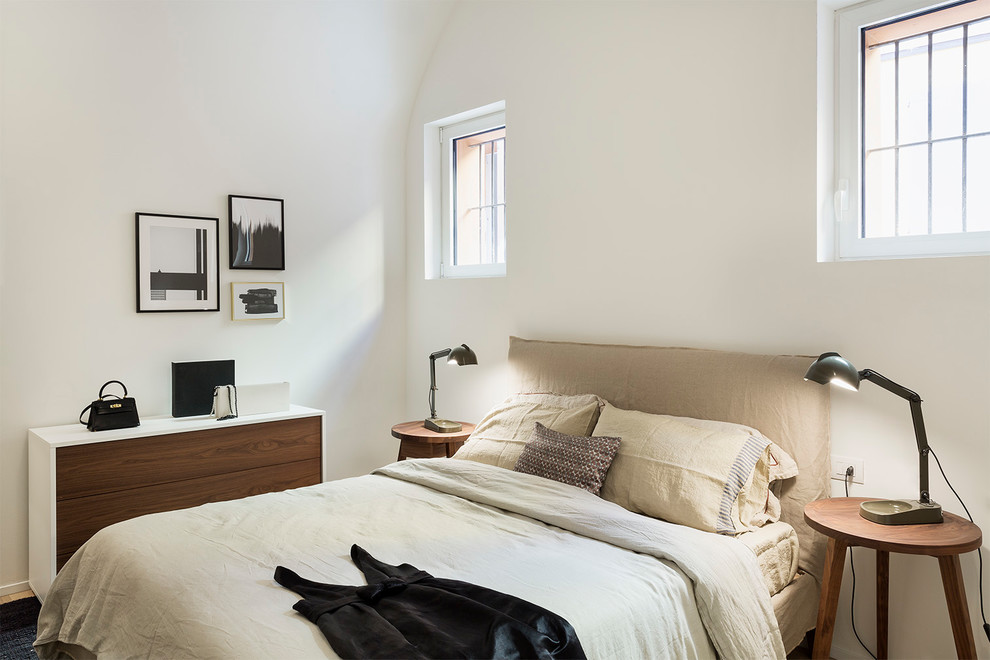 Inspiration for a mid-sized modern master bedroom in Bologna with white walls and black floor.