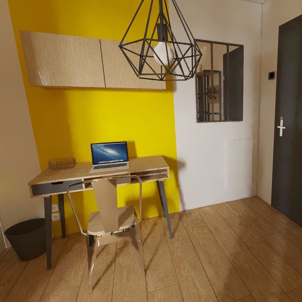 Photo of an industrial home studio in Lyon with yellow walls and a freestanding desk.