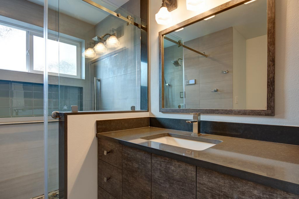 Inspiration for a small contemporary 3/4 bathroom in Seattle with a curbless shower, a wall-mount toilet, gray tile, white walls, pebble tile floors, multi-coloured floor, a sliding shower screen and grey benchtops.