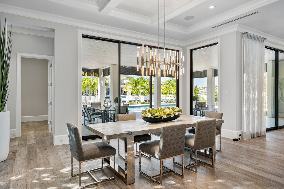 This is an example of a contemporary kitchen/dining combo in Miami with white walls, medium hardwood floors, brown floor and coffered.