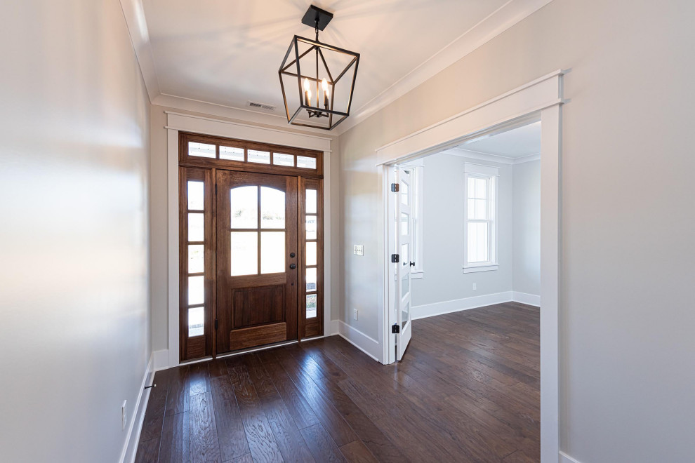 This is an example of a mid-sized traditional front door in Raleigh with grey walls, medium hardwood floors, a single front door, a medium wood front door and brown floor.