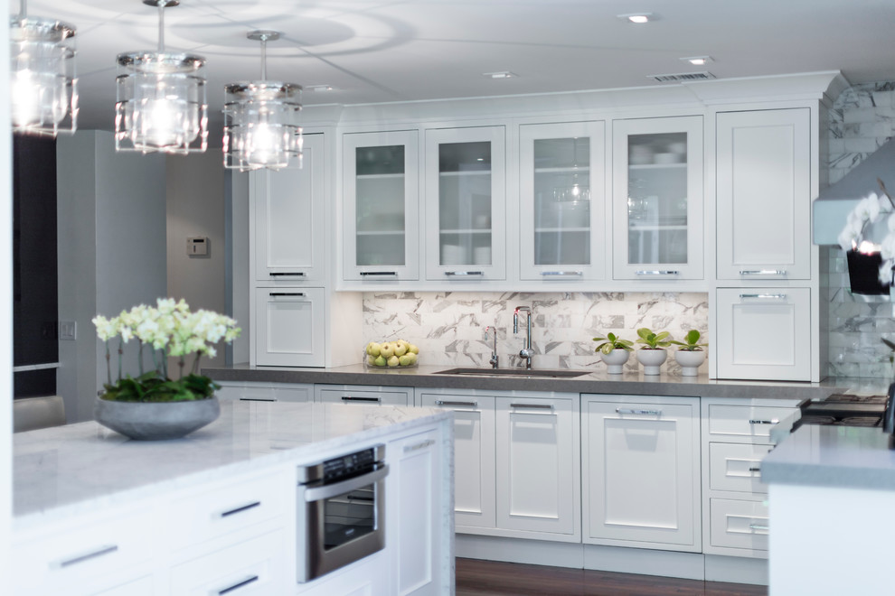 Inspiration for a large transitional galley dark wood floor eat-in kitchen remodel in Philadelphia with an undermount sink, recessed-panel cabinets, white cabinets, white backsplash, an island, quartzite countertops, ceramic backsplash and paneled appliances