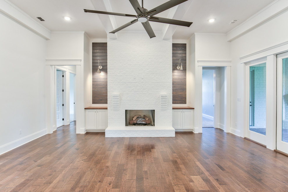 Photo of a traditional family room in Other with white walls and a brick fireplace surround.