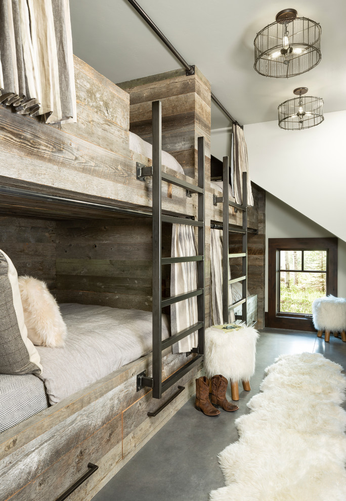 This is an example of a country gender-neutral kids' bedroom for kids 4-10 years old in Denver with white walls, concrete floors and grey floor.