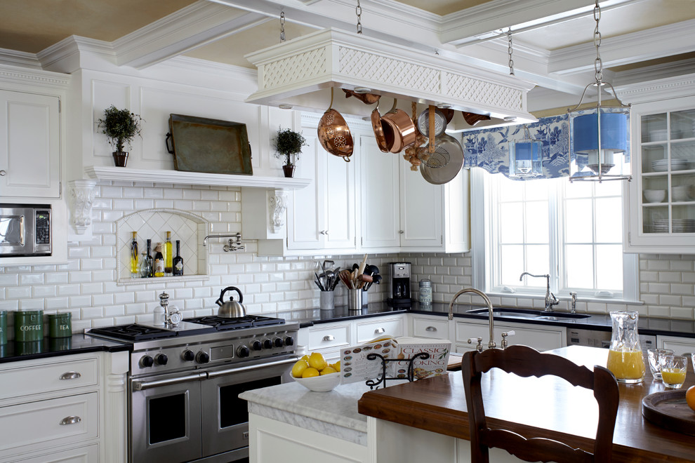 Kitchen - traditional l-shaped kitchen idea in New York with beaded inset cabinets, white cabinets, white backsplash, an island, a double-bowl sink and subway tile backsplash