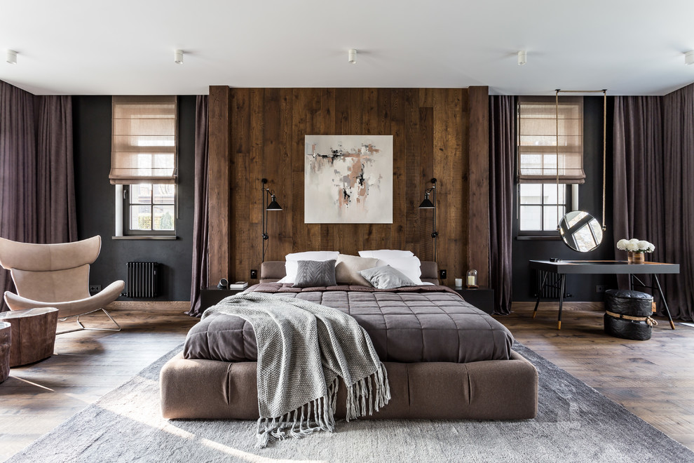 Expansive contemporary master bedroom in Moscow with black walls, dark hardwood floors, no fireplace and brown floor.
