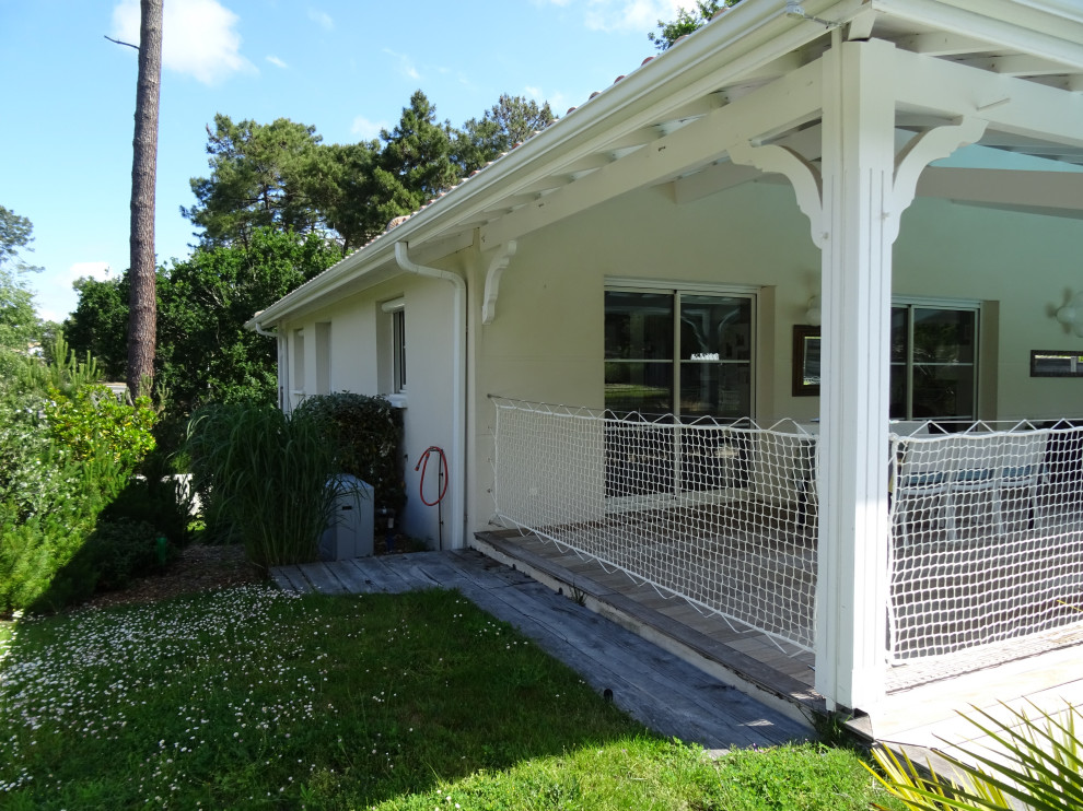 Idée de décoration pour un porche d'entrée de maison arrière marin de taille moyenne avec une terrasse en bois et une extension de toiture.
