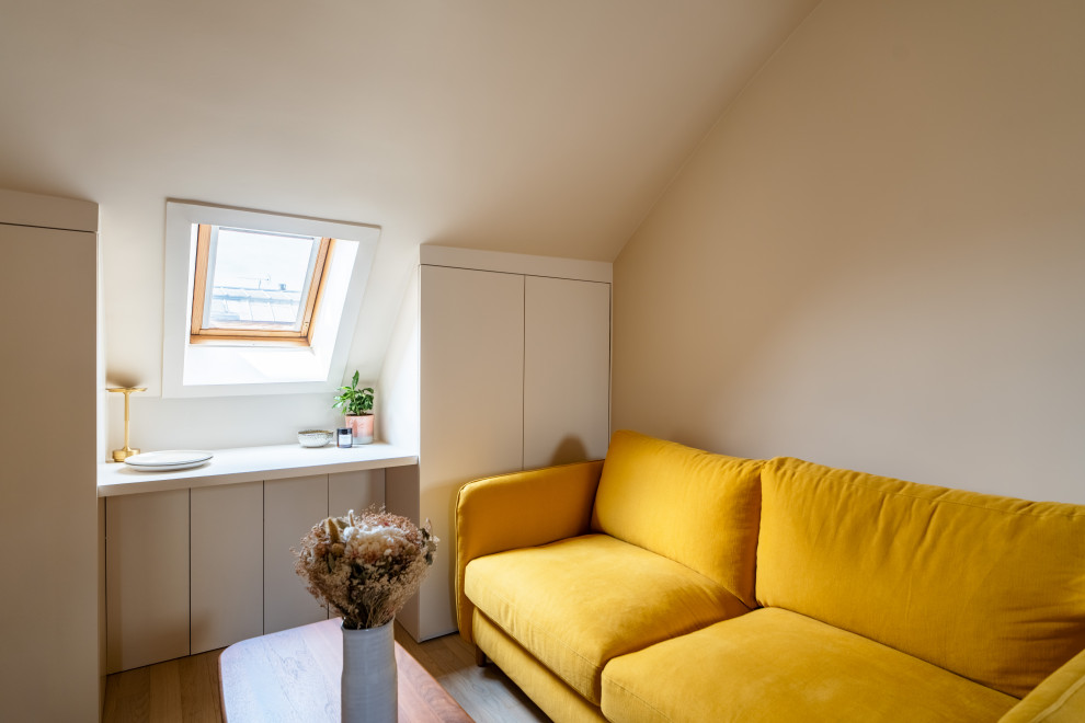 Immagine di un piccolo soggiorno moderno stile loft con libreria, pareti rosa, parquet chiaro, nessun camino e nessuna TV