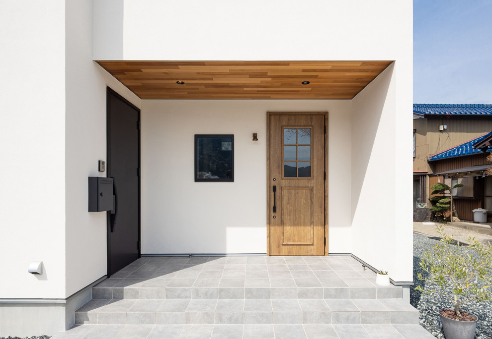 Esempio di una porta d'ingresso moderna con pareti bianche, pavimento con piastrelle in ceramica, una porta singola, una porta in legno bruno, pavimento grigio e soffitto in legno