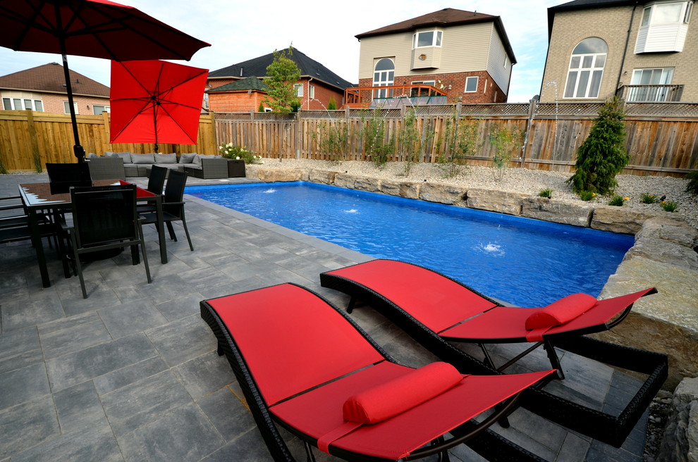 Inspiration for a modern rectangular pool in Toronto with a water feature and concrete pavers.