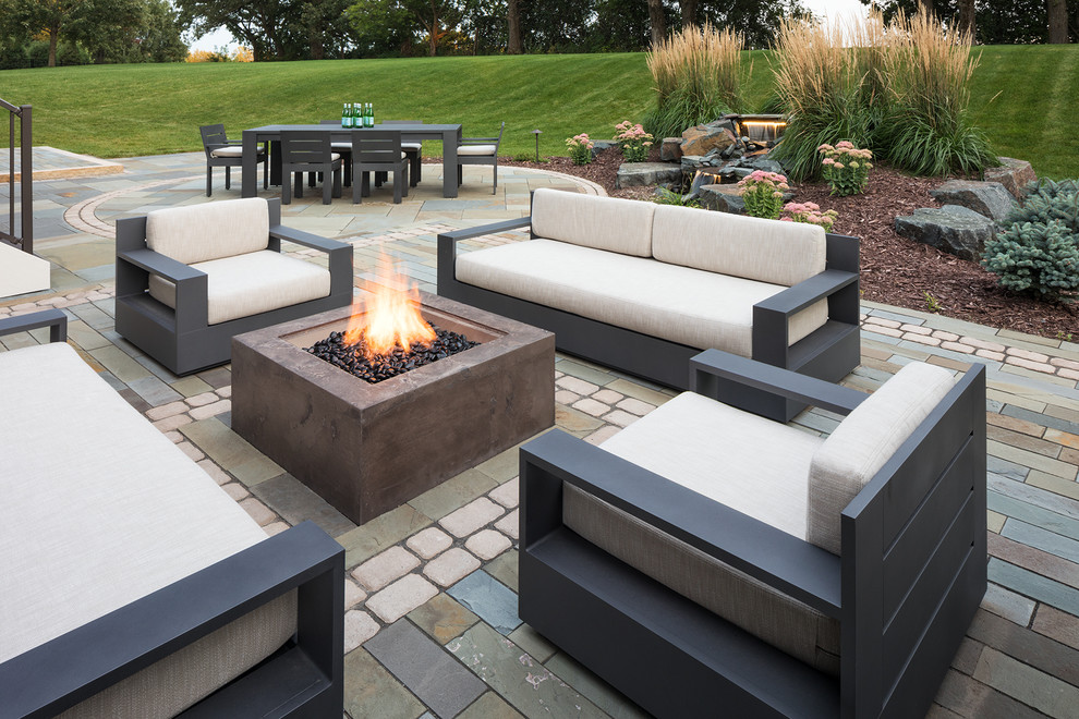 Photo of a mid-sized contemporary backyard patio in Minneapolis with a fire feature, no cover and concrete pavers.