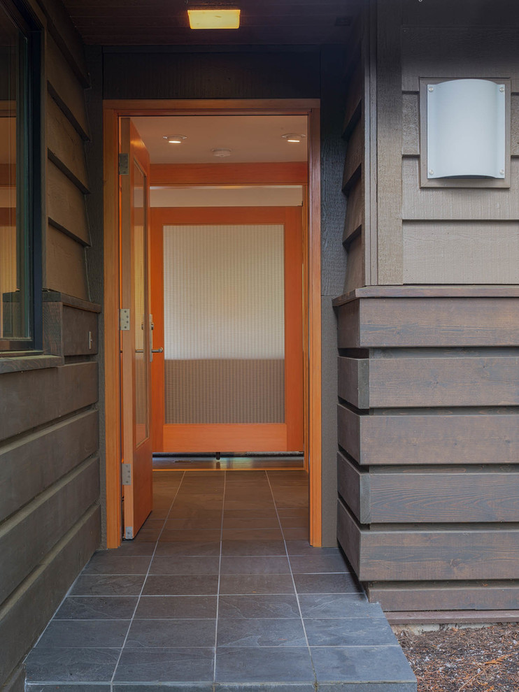 Inspiration for a mid-sized transitional slate floor entry hall remodel in Seattle with white walls and a medium wood front door