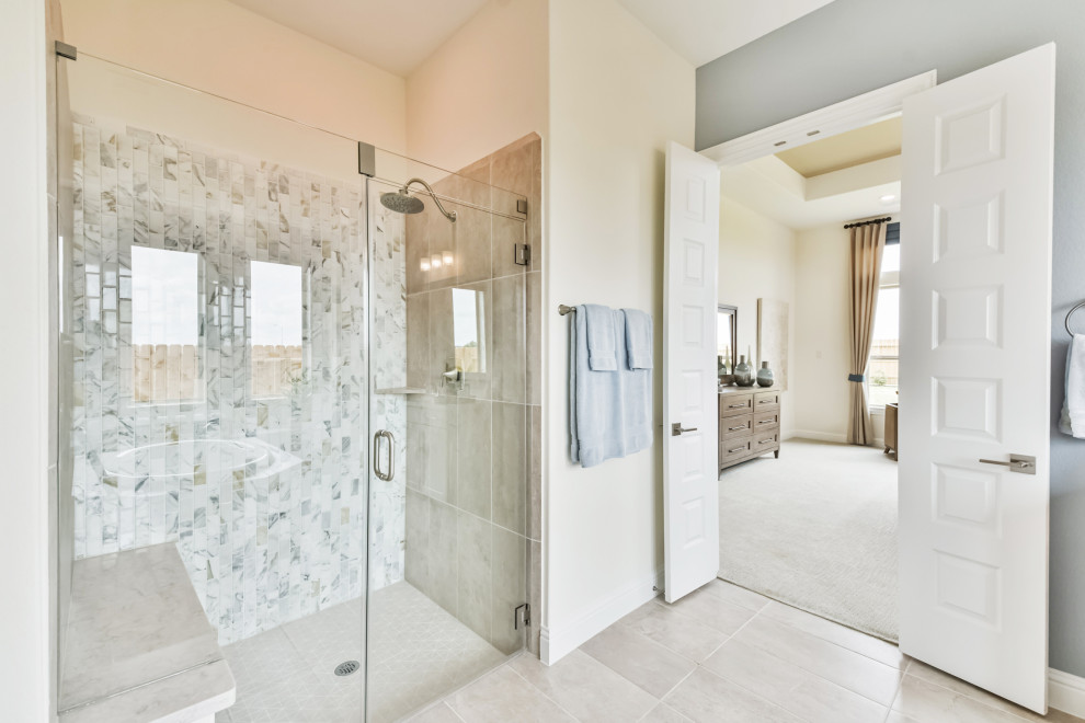This is an example of a mid-sized contemporary master bathroom in Houston with recessed-panel cabinets, grey cabinets, a drop-in tub, an alcove shower, multi-coloured tile, ceramic tile, ceramic floors, an undermount sink, solid surface benchtops, beige floor, a hinged shower door and beige benchtops.