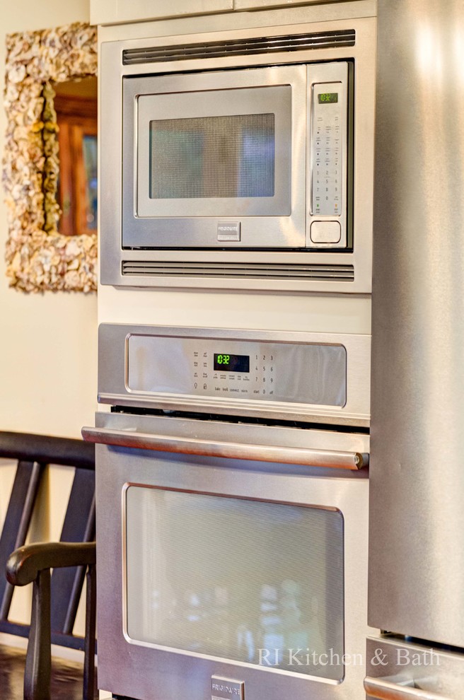 Eat-in kitchen - large transitional u-shaped light wood floor eat-in kitchen idea in Providence with an undermount sink, shaker cabinets, beige cabinets, granite countertops, brown backsplash, porcelain backsplash, stainless steel appliances and an island
