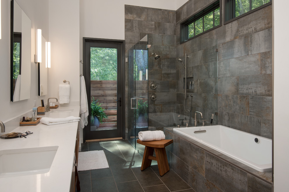 Photo of a contemporary 3/4 bathroom in Other with a drop-in tub, a corner shower, gray tile, white walls, an undermount sink, grey floor and a hinged shower door.