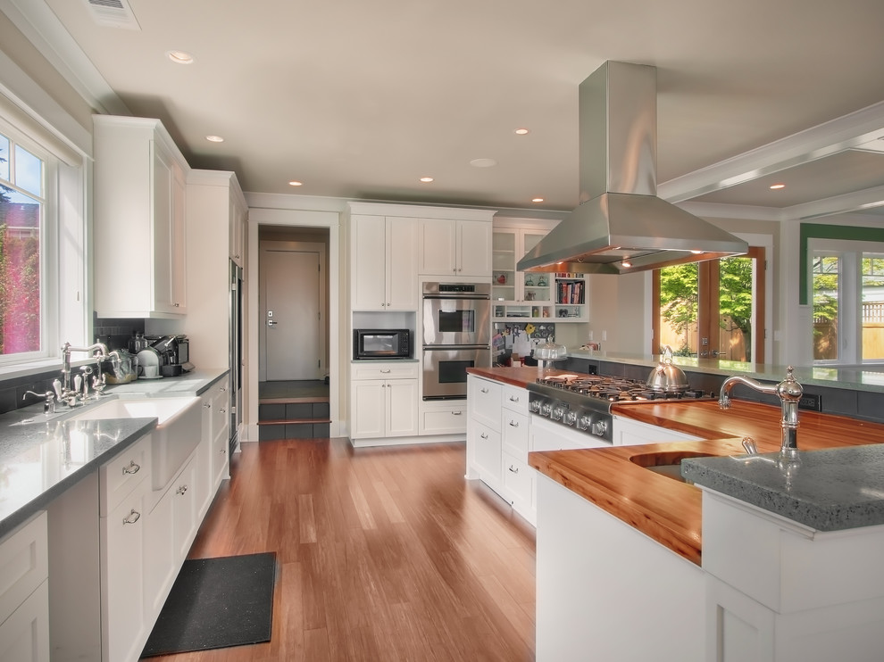 Contemporary kitchen in Seattle with stainless steel appliances, a farmhouse sink and wood benchtops.