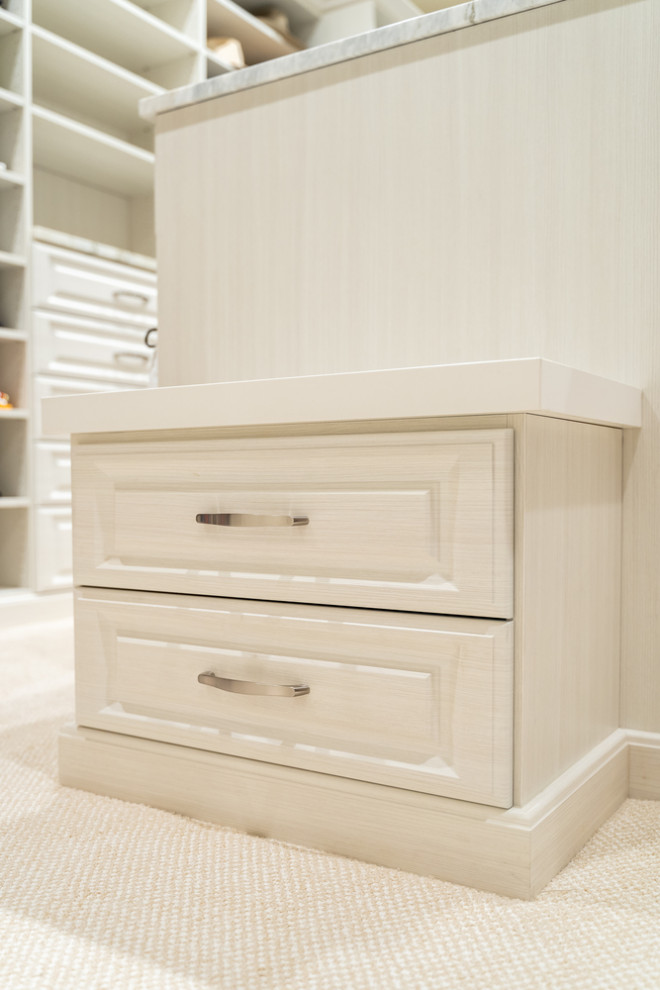 This is an example of a large transitional gender-neutral dressing room in Oklahoma City with raised-panel cabinets, light wood cabinets, carpet and beige floor.