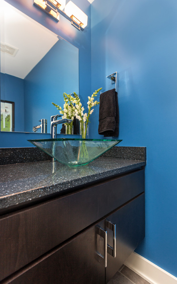 Small transitional powder room in Other with a vessel sink, flat-panel cabinets, dark wood cabinets, a two-piece toilet, blue walls, porcelain floors and solid surface benchtops.