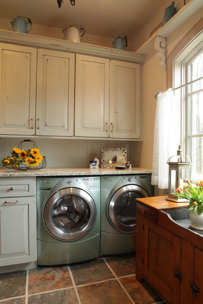 Inspiration for a large traditional utility room in St Louis with white cabinets, raised-panel cabinets, granite benchtops, beige walls, slate floors and a side-by-side washer and dryer.
