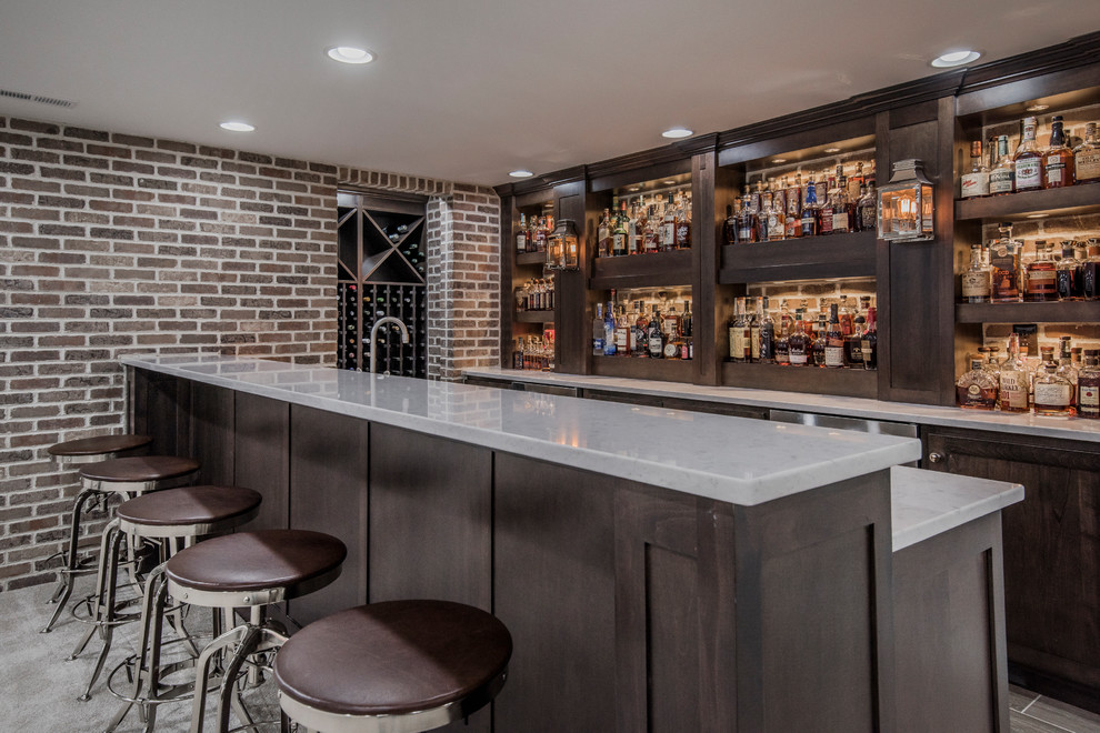 Inspiration for a country galley seated home bar in Columbus with shaker cabinets, dark wood cabinets, brick splashback, carpet and grey floor.
